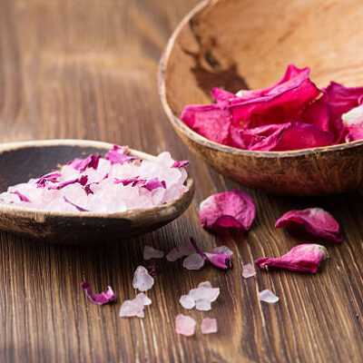 Homeopathic medicine, rose dry flowers and wooden surface.