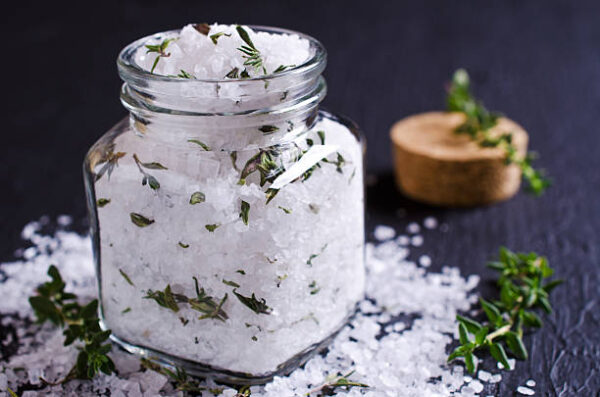 Salt and thyme in a glass on a dark background. selective focus.