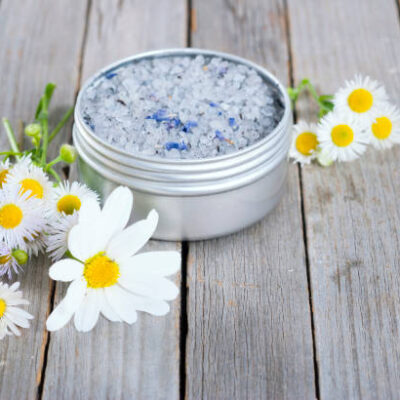 Blue bath salt in tin pot on natural old wood table texture
