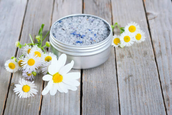 Blue bath salt in tin pot on natural old wood table texture
